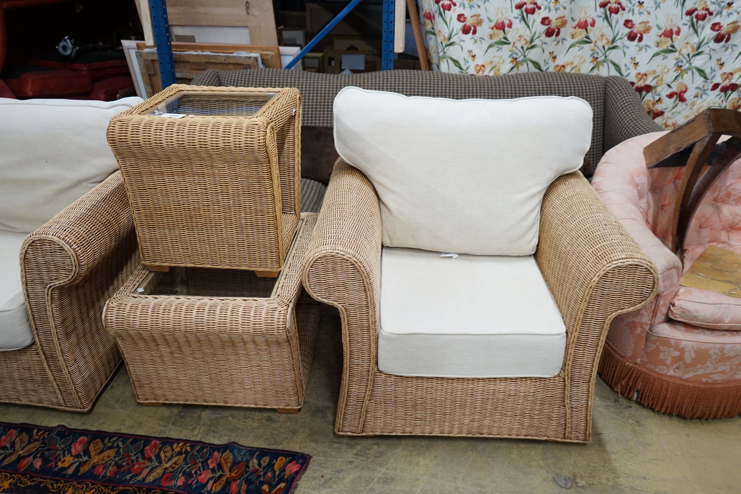 A contemporary rattan and natural fabric four piece conservatory suite, comprising settee, length 180cm, depth 86cm, height 85cm, armchair and two glass top tables